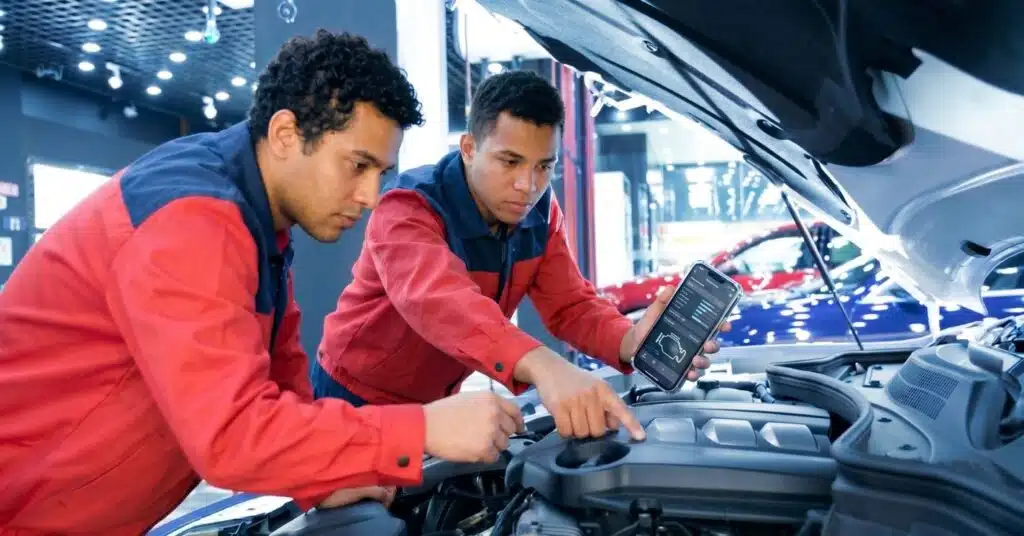 Vendedor de revenda fazendo avaliação de um carro seminovo no pátio da loja